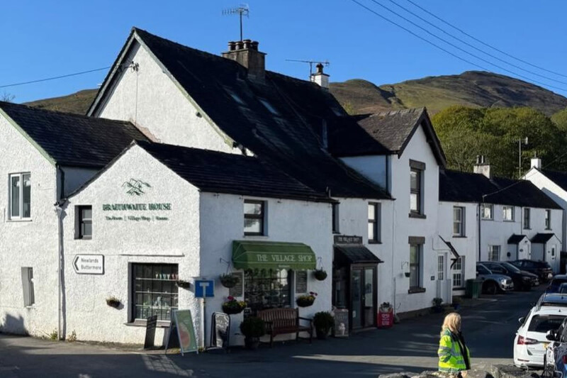 Whitewashed building with fells behind at Braithwaite Village Shop and Tea Room, near Keswick