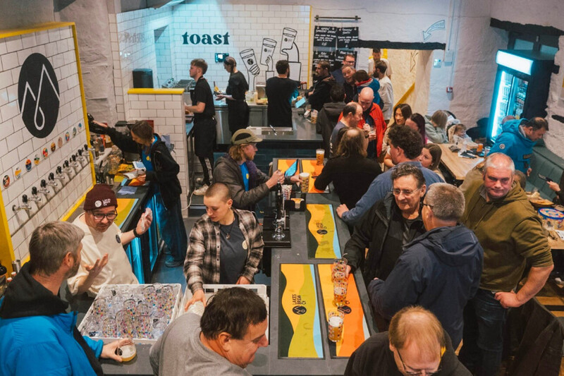 Busy tap room with people drinking at the bar at Lakes Brew Co, Cumbria